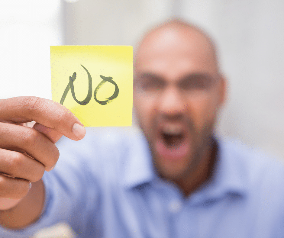 A person standing up for themselves, holding up a 'no' sign as a way to handle boundary violations